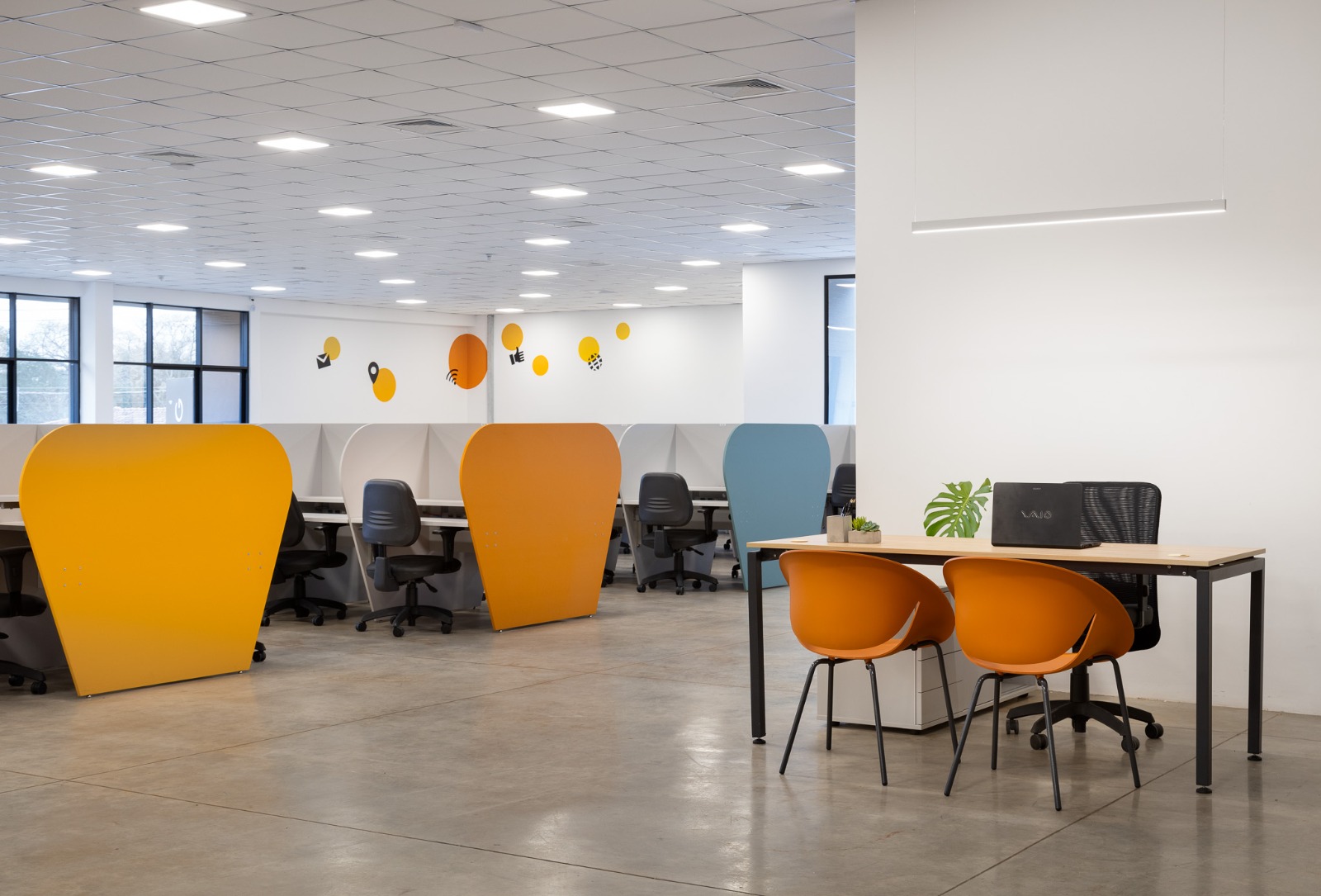 Call center con estaciones de trabajo y divisorias coloridas