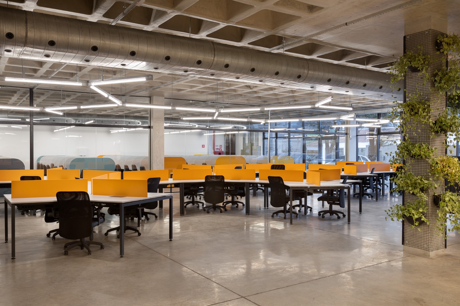 Open space corporativo con plataformas angulares y jardín vertical